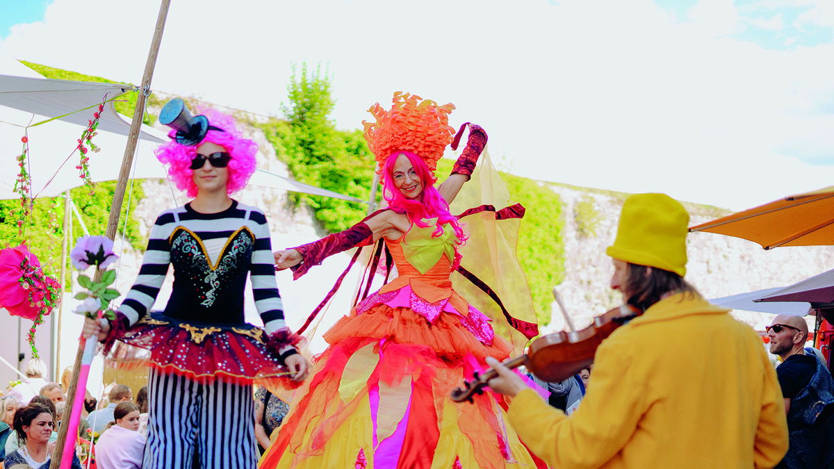 Stelzenkünstlerinnen Madame Feu de la Vie mit Geiger auf der Rosenmesse Kronach